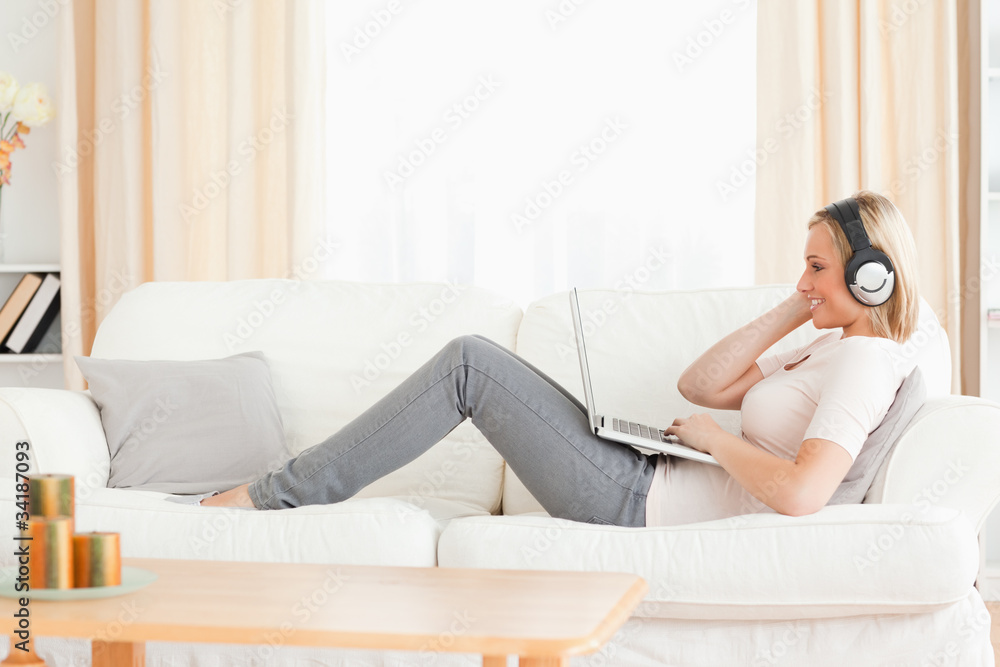 Smling woman watching a movie with her laptop Smling woman watching a movie with her laptop
