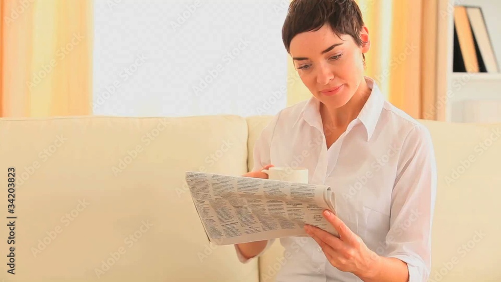 Woman drinking tea while reading the news