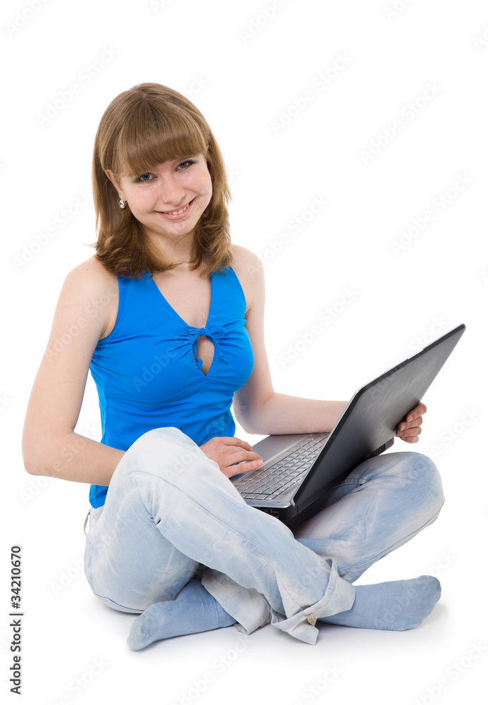 Naklejka premium girl sitting with a laptop in blue jeans.