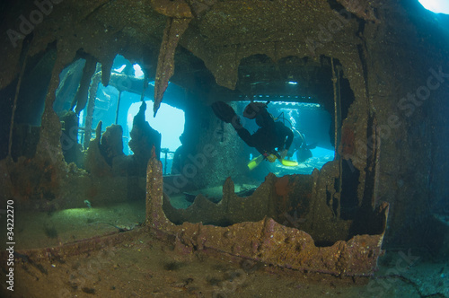 Obraz na plátně Divers exploring a large shipwreck