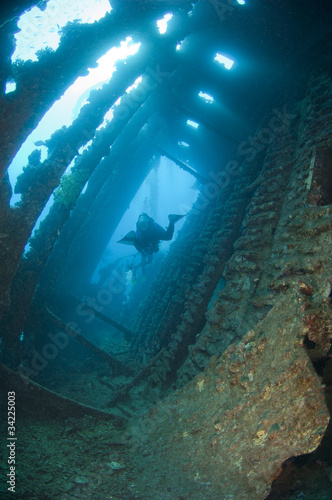 Divers exploring a large shipwreck