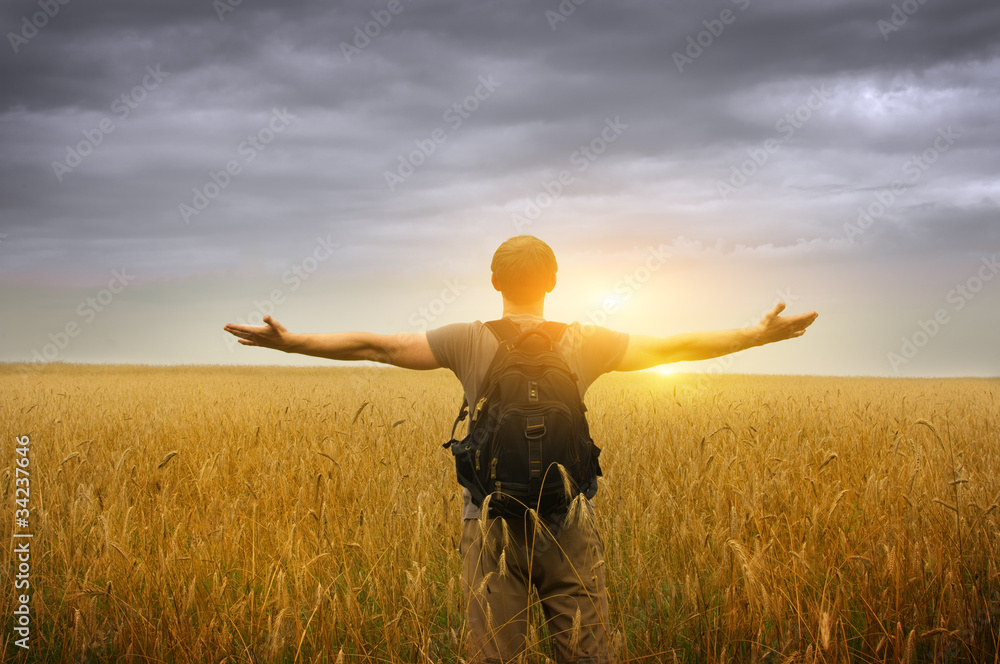 Young man standing on a wheat field Young man standing on a wheat field
