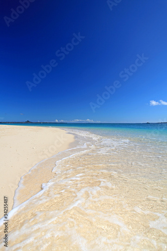 真っ白な砂浜に打ち寄せる波と青い空