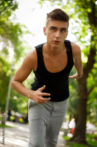 Closeup portrait of young man running in park