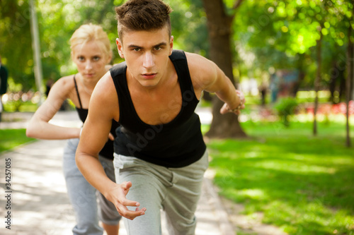 Fototapeta Naklejka Na Ścianę i Meble -  Closeup Portrait of Young Couple Jogging In Park