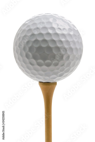 Closeup of golf ball sitting on tee isolated on white