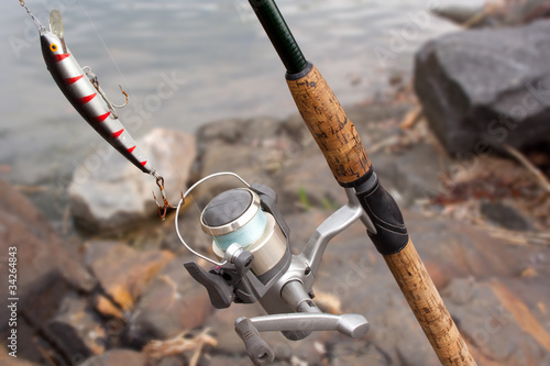 Fishing rod with reel and minnow in the beach