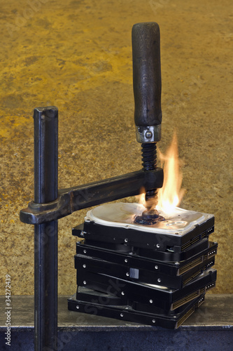 burning stack of hard drive pressed together with clamp photo
