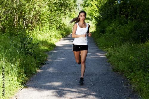 young woman jogging in the park in summer