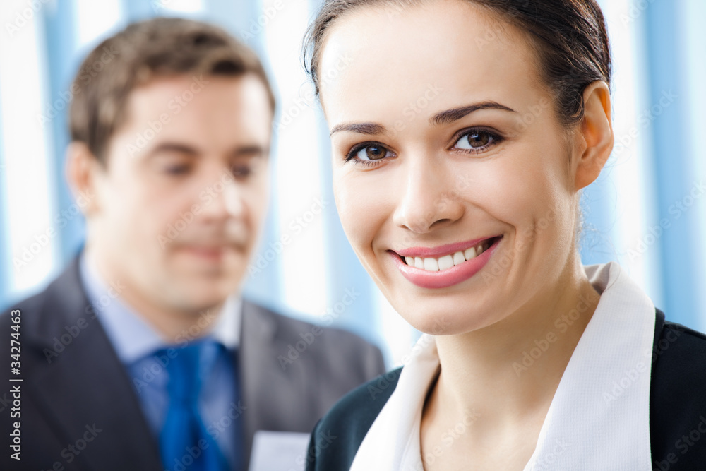 Smiling young businesswoman and colleague, at office Smiling young businesswoman and colleague, at office