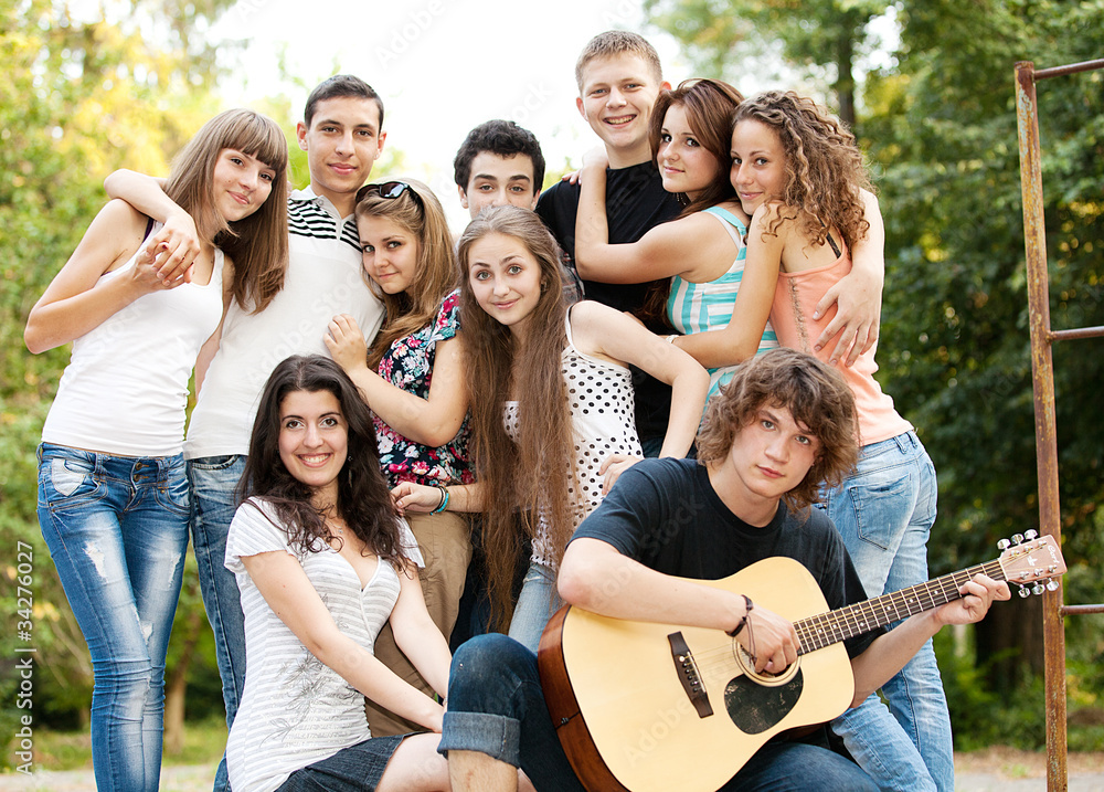 Obraz premium Cheerful teenagers playing guitar and singing