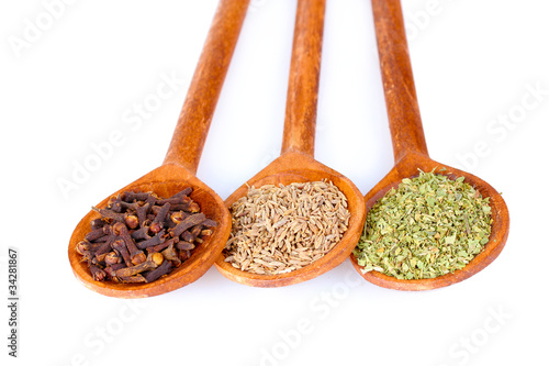spices in the spoons isolated on white