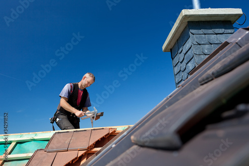 dachdecker arbeitet mit schieferhammer