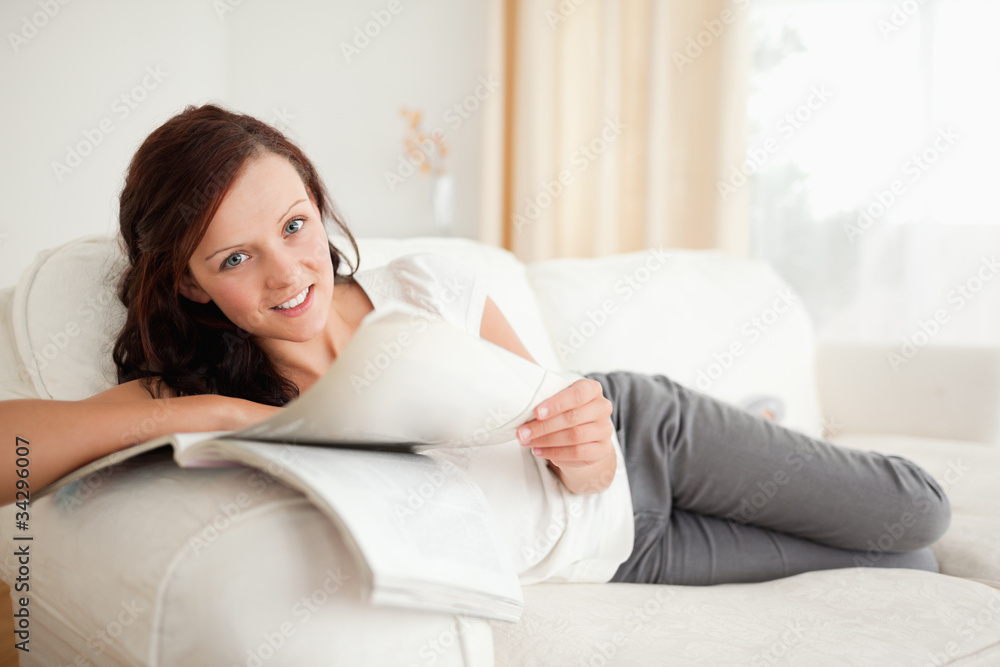 Young woman studying on the sofa looking into the camera Young woman studying on the sofa looking into the camera
