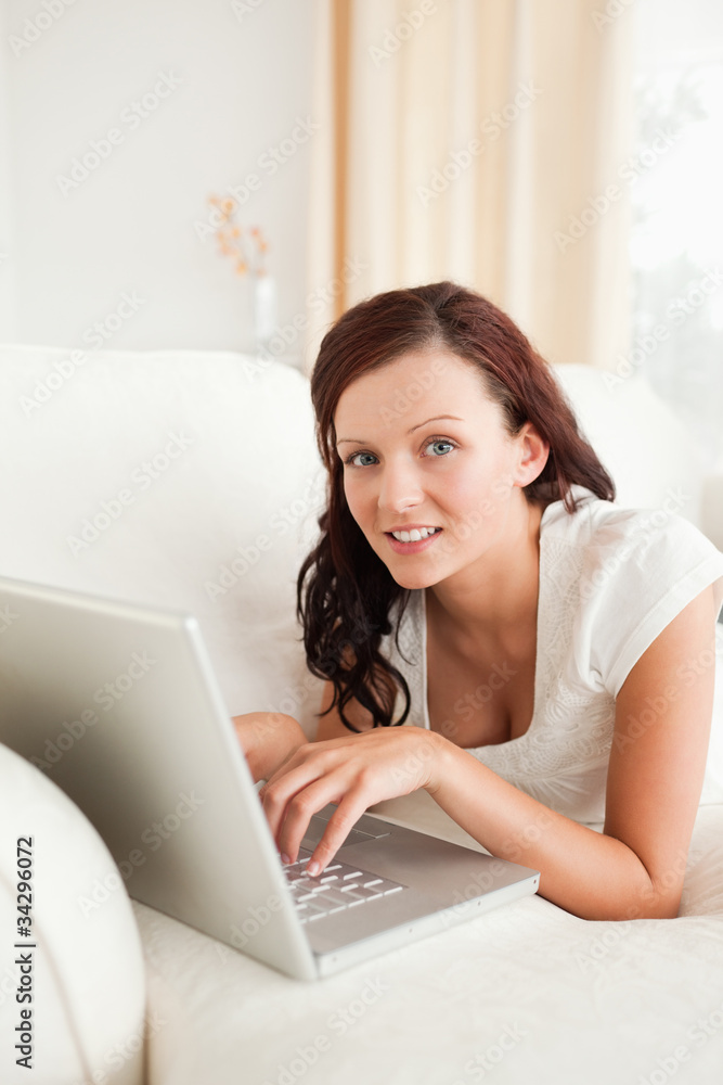 Relaxed red-haired woman with laptop looking into the camera Relaxed red-haired woman with laptop looking into the camera