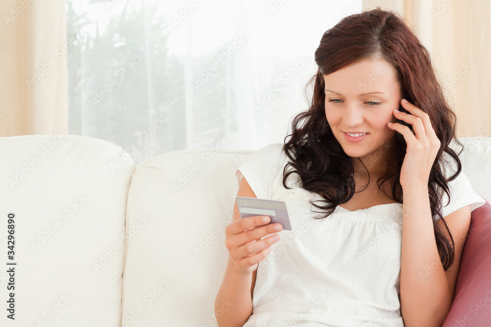 Smiling woman on the phone holding a card Smiling woman on the phone holding a card