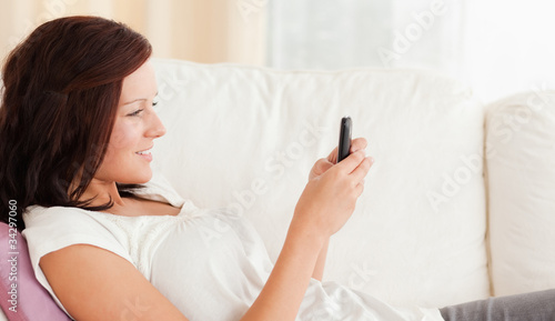 Woman texting while sitting on the sofa
