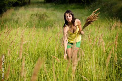 Wallpaper Mural woman  enjoying picking wild flowers in a green field. Torontodigital.ca