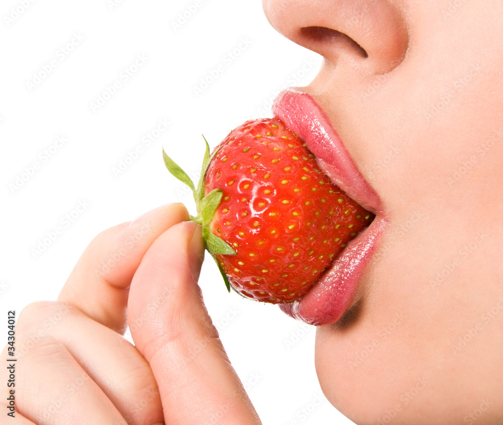 young girl mouth with a strawberry against white background young girl mouth with a strawberry against white background