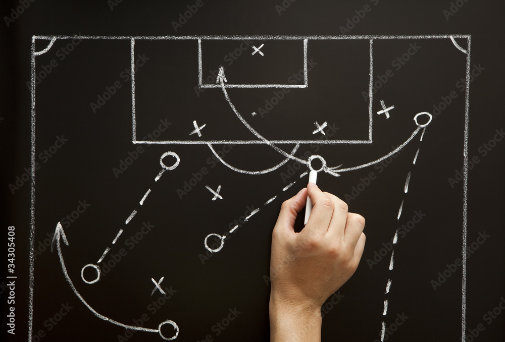 Fototapeta premium Coach drawing a soccer football game strategy in the locker room