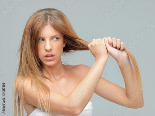 young woman pulling her damadged hair photo