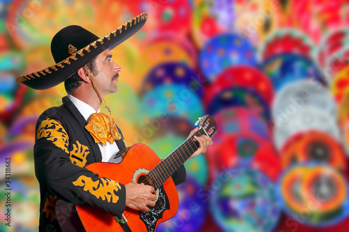 Charro Mariachi playing guitar over colorful blur photo
