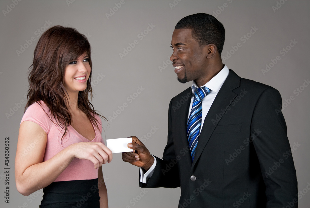 Businessman giving his business card to a young woman Businessman giving his business card to a young woman