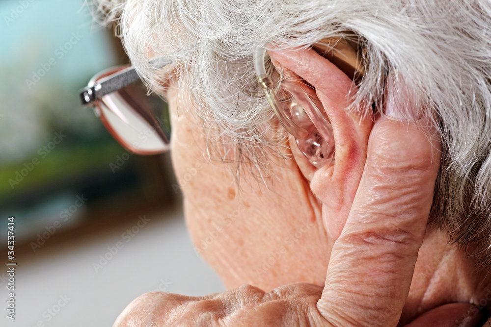 Obraz premium kobieta w wieku z okularami i aparatem słuchowym