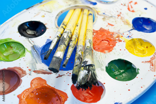 Set of brushes and a palette of colorful paint.