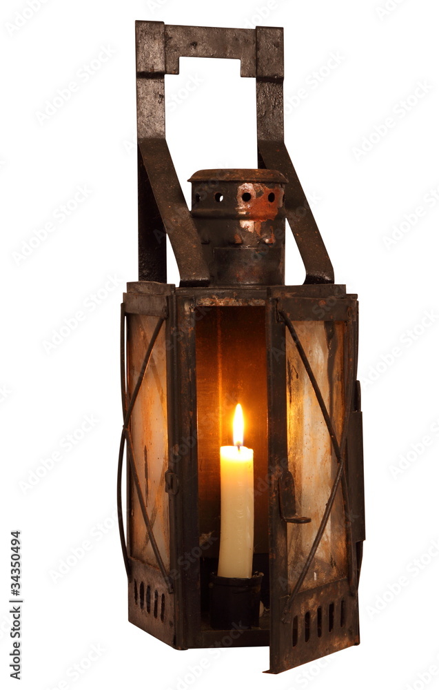 Old lamp with alight candle, isolated on white background
