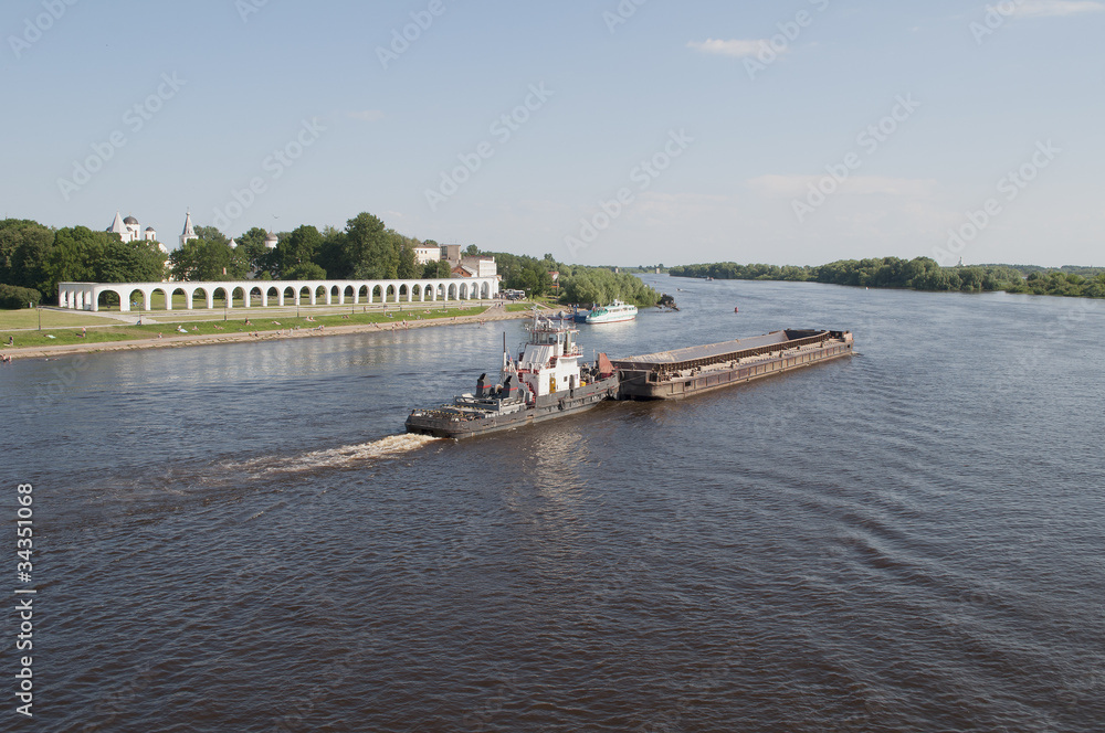 Obraz premium Буксир с баржей на реке Волхов в Великом Новгороде