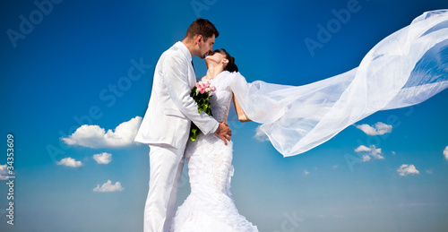 newly married couple.wind lifting long white bridal wedding photo