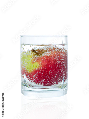 Red apple in glass of mineral water
