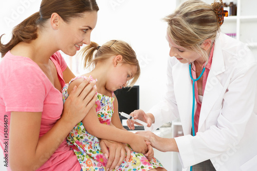 Female doctor injecting child photo