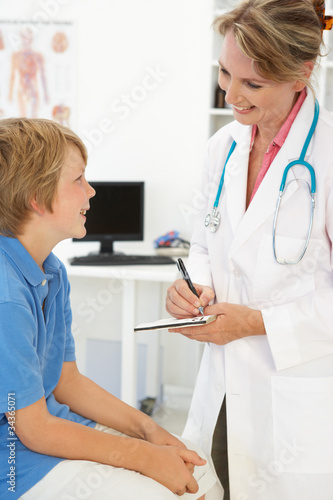 Female doctor talking to young boy photo