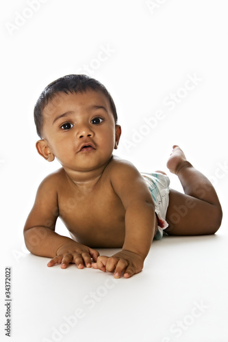 Sweet Indian baby lying on floor