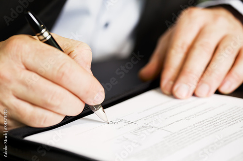 Close up of businessman signing a contract. © lichtmeister