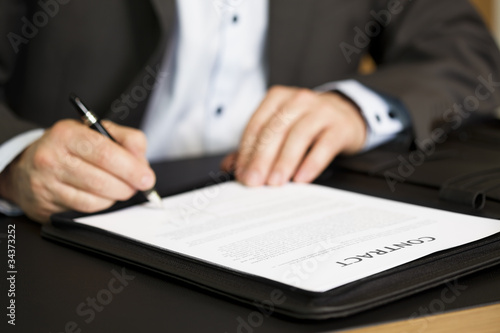 Businessman signing a contract.
