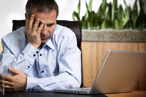 Frustrated businessman at laptop. photo