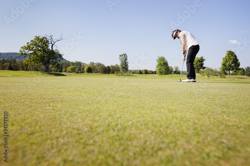 Female golf player putting.