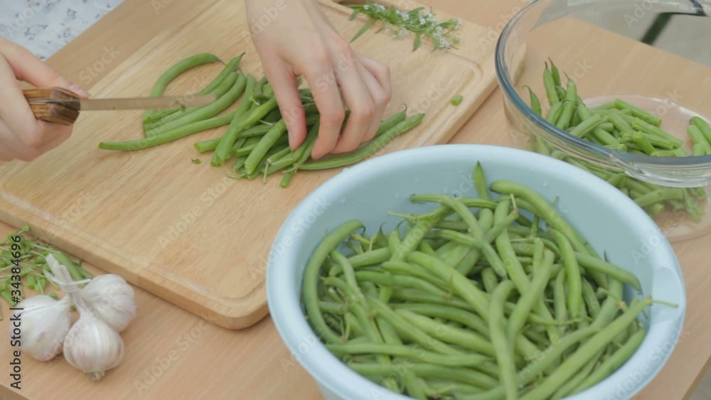 Cutting the remaining stems from fresh green beans outdoors Cutting the remaining stems from fresh green beans outdoors