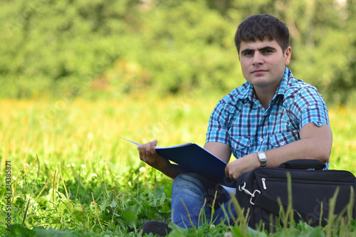 portrait of a man in a park with a book