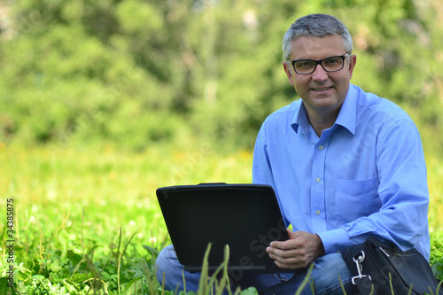 portrait of a man in a park with a laptop