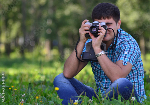 portrait of a man in a park with a camera