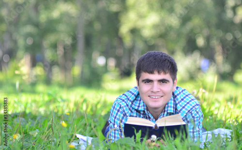 portrait of a man in a park with a book