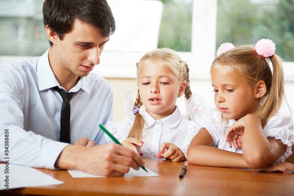 Teacher helping elementary school pupils with their tasks Teacher helping elementary school pupils with their tasks