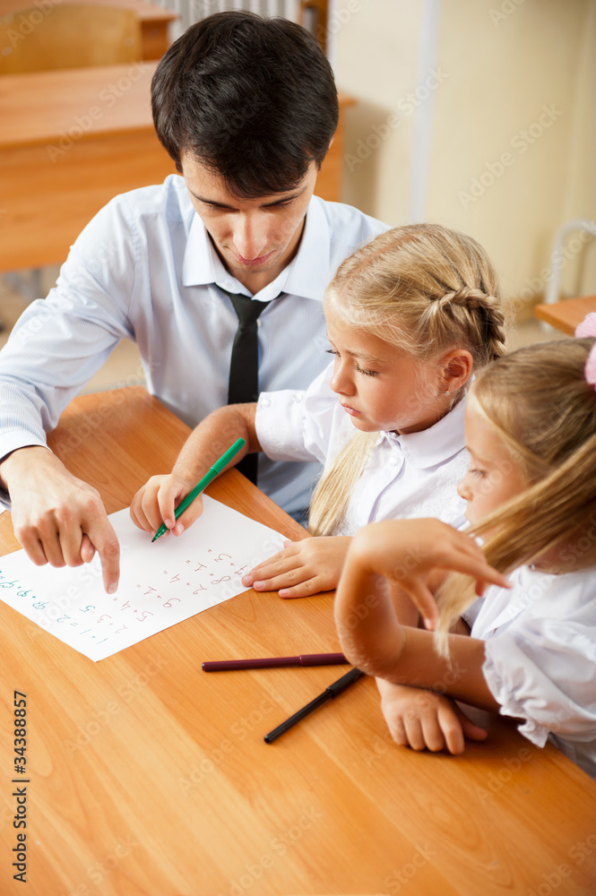Teacher helping elementary school pupils with their tasks Teacher helping elementary school pupils with their tasks