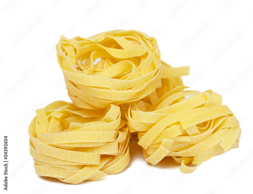 heap of raw dry nest pasta over white background heap of raw dry nest pasta over white background
