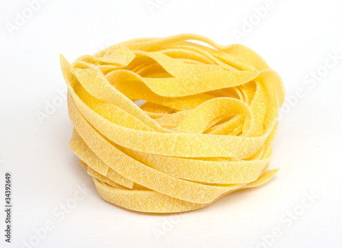 heap of raw dry nest pasta over white background