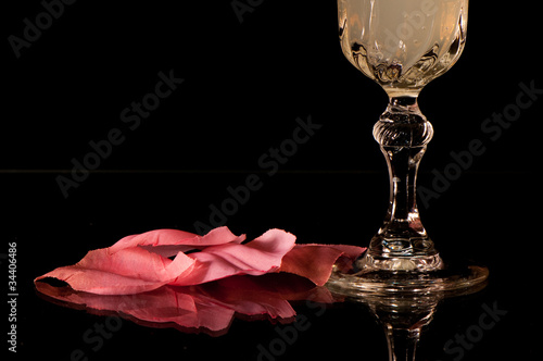Copa de cristal y pétalos de rosa